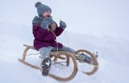 girl sledding down a hill in the snow.jpg